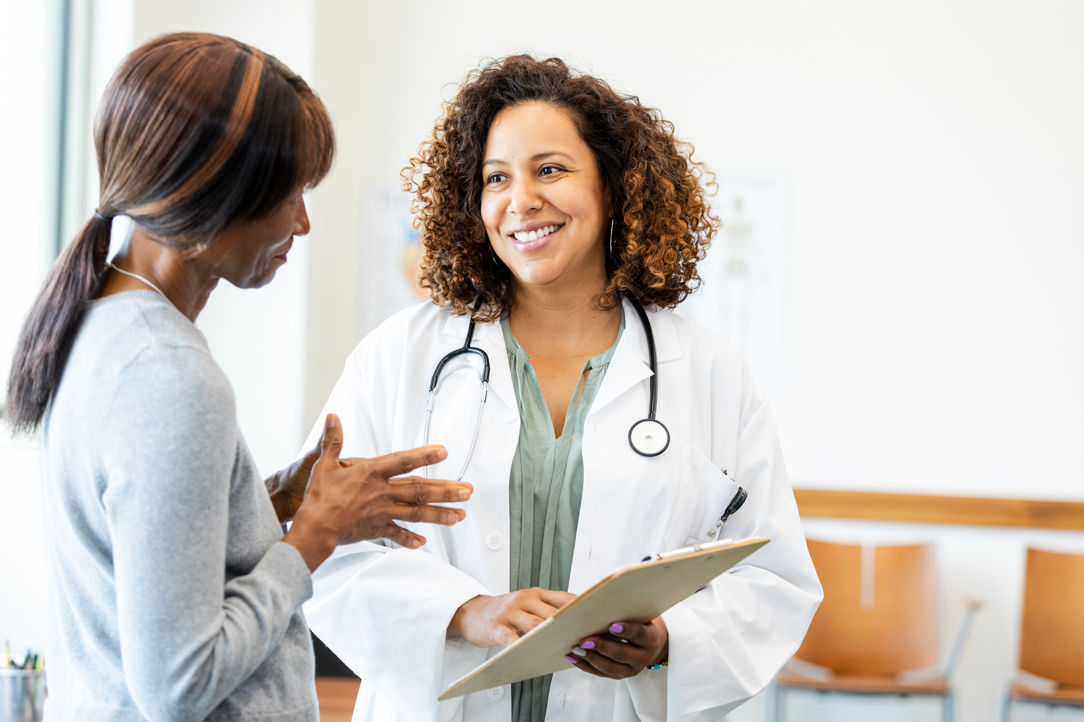 Female doctor and patient talking; healthcare, medicine, consultation.